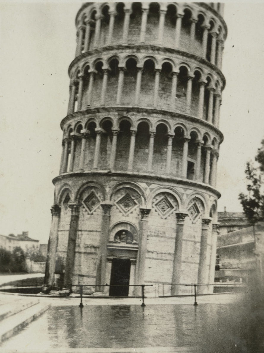Image: The famous cylindrical tower, leaning to the right with puddles forming on the ground in front.