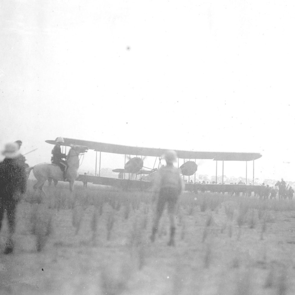 Image: biplane landing with people watching