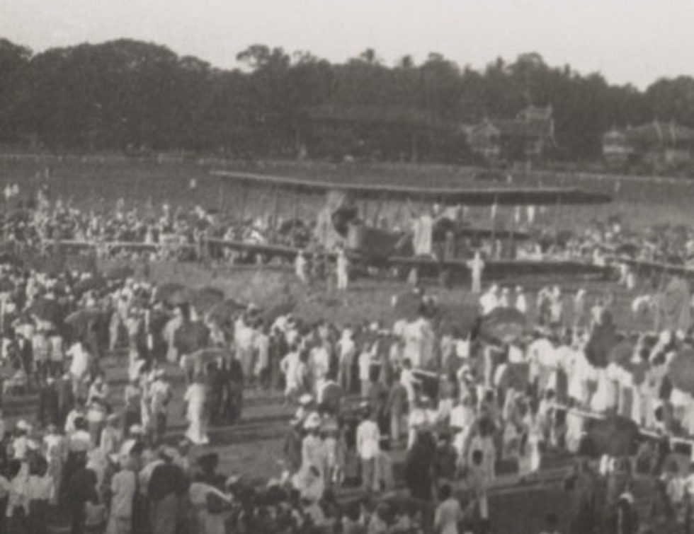 Image: Biplane on open field surrounded by onlookers