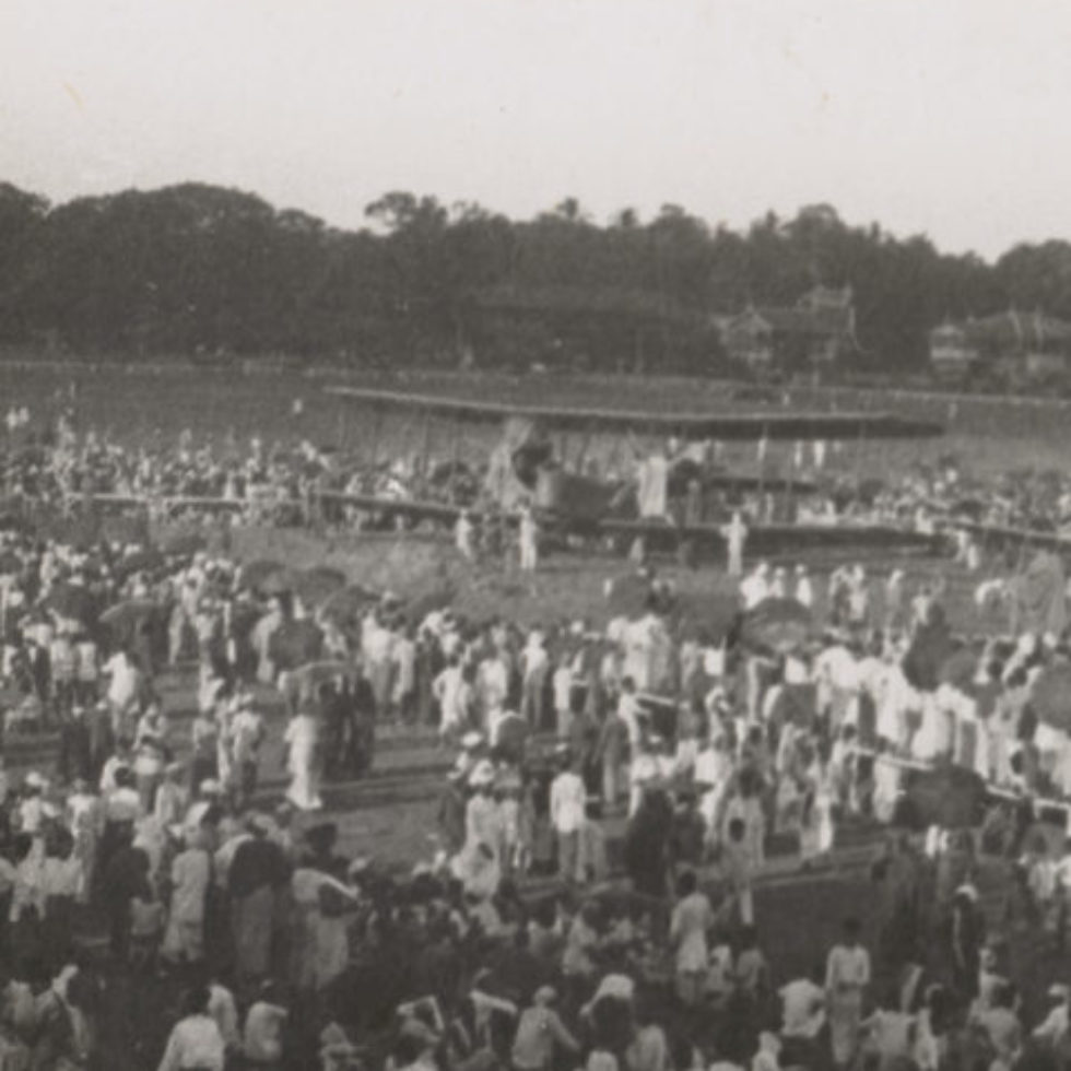 Image: Biplane on open field surrounded by onlookers