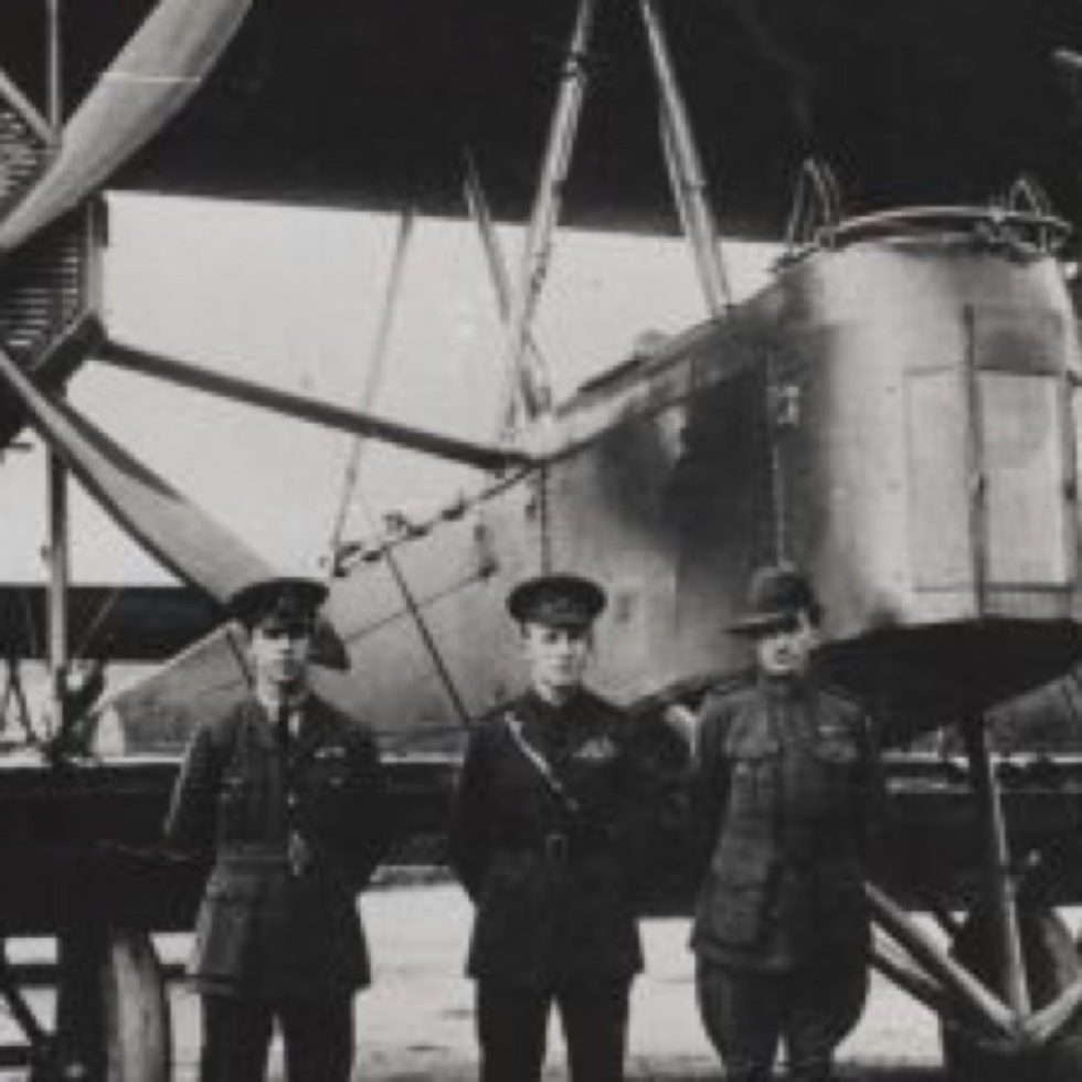 Four flight crew members standing in front of the large bi-plane